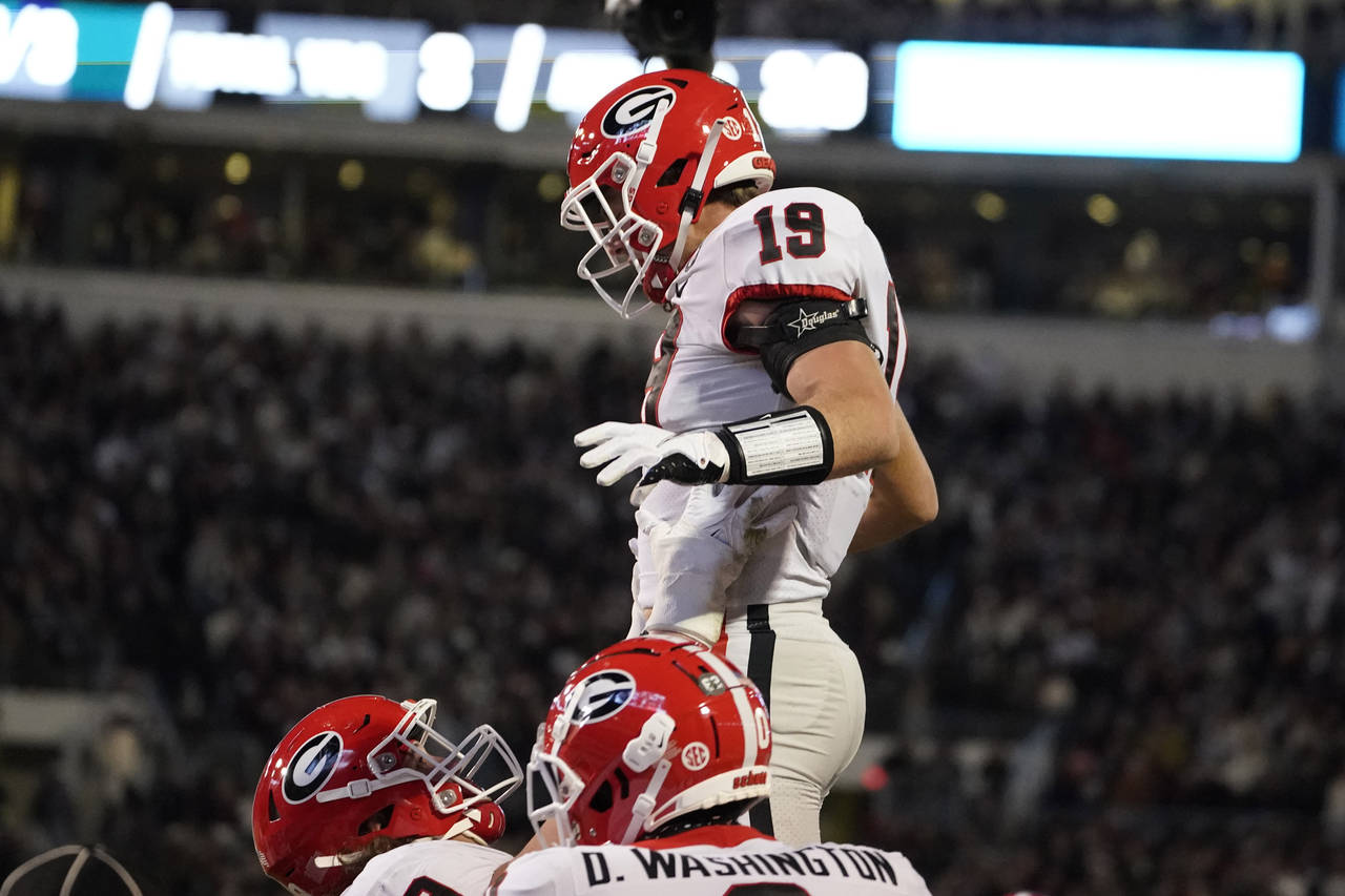 Georgia tight end Brock Bowers (19) is lifted by a teammate after scoring on a two-yard touchdown p...