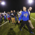 
              FILE - Bremerton High assistant football coach Joe Kennedy, front, walks off the field with his lawyer, right, Oct. 16, 2015, after praying at the 50-yard line following a football game in Bremerton, Wash. Across America, most high school football seasons are winding down. It will wrap up the first year since the Supreme Court ruled it was OK for a public school coach near Seattle to pray on the field. (Lindsey Wasson/The Seattle Times via AP, File)
            