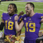 
              Minnesota Vikings wide receiver Justin Jefferson (18) and wide receiver Adam Thielen (19) eat turkey legs before being interviewed after an NFL football game against the New England Patriots, Thursday, Nov. 24, 2022, in Minneapolis. The Vikings won 33-26. (AP Photo/Andy Clayton-King)
            