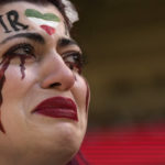 
              An Iranian woman, name not given, breaks into tears after a member of security seized her flag reading "Woman Life Freedom" before the start of the World Cup group B soccer match between Wales and Iran, at the Ahmad Bin Ali Stadium in Al Rayyan, Qatar, Friday, Nov. 25, 2022. (AP Photo/Alessandra Tarantino)
            