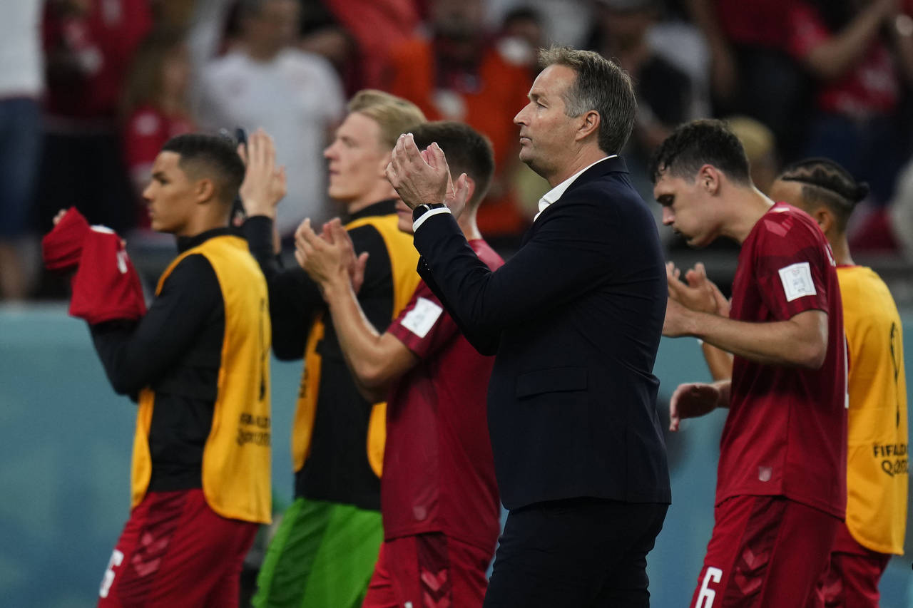 Denmark's head coach Kasper Hjulmand, center, applauds with teammates to supporters at the end of t...