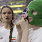 
              A group of young women, some, wearing colorful balaclavas who identified themselves as members of the Pussy Riot collective in the stands during the World Cup group B soccer match between Iran and the United States at the Al Thumama Stadium in Doha, Qatar, Tuesday, Nov. 29, 2022. (AP Photo/Ciaran Fahey)
            