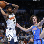 
              Denver Nuggets forward Bruce Brown, left, passes the ball away from Oklahoma City Thunder guard Josh Giddey during the first half of an NBA basketball game Thursday, Nov. 3, 2022, in Oklahoma City. (AP Photo/Nate Billings)
            