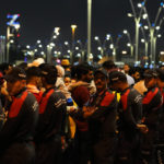 
              Policemen stand in line to limit the number of fans entering the fan zone to watch the World Cup, group A soccer match between Qatar and Ecuador in Doha, Sunday, Nov. 20, 2022. (AP Photo/Petr David Josek)
            