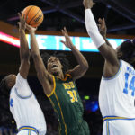 
              Norfolk State guard Cahiem Brown, center, shoots as UCLA guard Dylan Andrews, left, and forward Kenneth Nwuba defend during the first half of an NCAA college basketball game Monday, Nov. 14, 2022, in Los Angeles. (AP Photo/Mark J. Terrill)
            