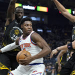 
              New York Knicks guard RJ Barrett, foreground, is defended by Golden State Warriors forward Draymond Green (23) and guard Klay Thompson during the first half of an NBA basketball game in San Francisco, Friday, Nov. 18, 2022. (AP Photo/Jeff Chiu)
            