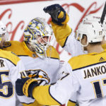 
              Nashville Predators goalie Kevin Lankinen celebrates with Alexandre Carrier, left, and Mark Jankowski after the Predators defeated the Calgary Flames in an NHL hockey game in Calgary, Alberta, Thursday, Nov. 3, 2022. (Larry MacDougal/The Canadian Press via AP)
            
