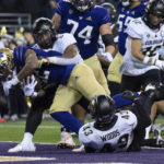 
              Washington running back Cameron Davis scores a touchdown against Colorado linebacker Josh Chandler-Semedo, second from left, and defensive back Trevor Woods during the first half of an NCAA college football game, Saturday, Nov. 19, 2022, in Seattle. (AP Photo/Stephen Brashear)
            