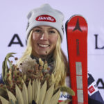 
              The winner United States' Mikaela Shiffrin celebrates on podium after an alpine ski, women's World Cup slalom, in Levi, Finland, Saturday, Nov. 19, 2022. (AP Photo/Alessandro Trovati)
            