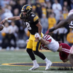 
              Iowa quarterback Alex Padilla (8) fumbles as he is tackled by Nebraska linebacker Eteva Mauga-Clements (5) during the first half of an NCAA college football game, Friday, Nov. 25, 2022, in Iowa City, Iowa. (AP Photo/Charlie Neibergall)
            