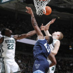 
              Michigan State's Mady Sissoko, left, and Joey Hauser, right, and Villanova's Eric Dixon (43) reach for a rebound during the first half of an NCAA college basketball game Friday, Nov. 18, 2022, in East Lansing, Mich. (AP Photo/Al Goldis)
            