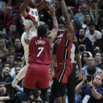 
              Portland Trail Blazers forward Jerami Grant (9) takes a shot against Miami Heat forward Jimmy Butler (22) and guard Kyle Lowry (7) during the second half of an NBA basketball game, Monday, Nov. 7, 2022, in Miami. (AP Photo/Wilfredo Lee)
            