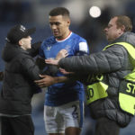 
              A young fan is restrained bt a steward as he approaches Rangers' James Tavernier, centre, after the end of the Champions League group A soccer match between, Glasgow Rangers and Ajax, at Ibrox stadium in Glasgow, Scotland, Tuesday, Nov. 1, 2022. Ajax won the game 3-1 (AP Photo/Scott Heppell)
            