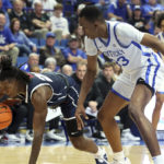 
              Howard's Shy Odom, left, dives for the ball next to Kentucky's Ugonna Onyenso (33) during the first half of an NCAA college basketball game in Lexington, Ky., Monday, Nov. 7, 2022. (AP Photo/James Crisp)
            