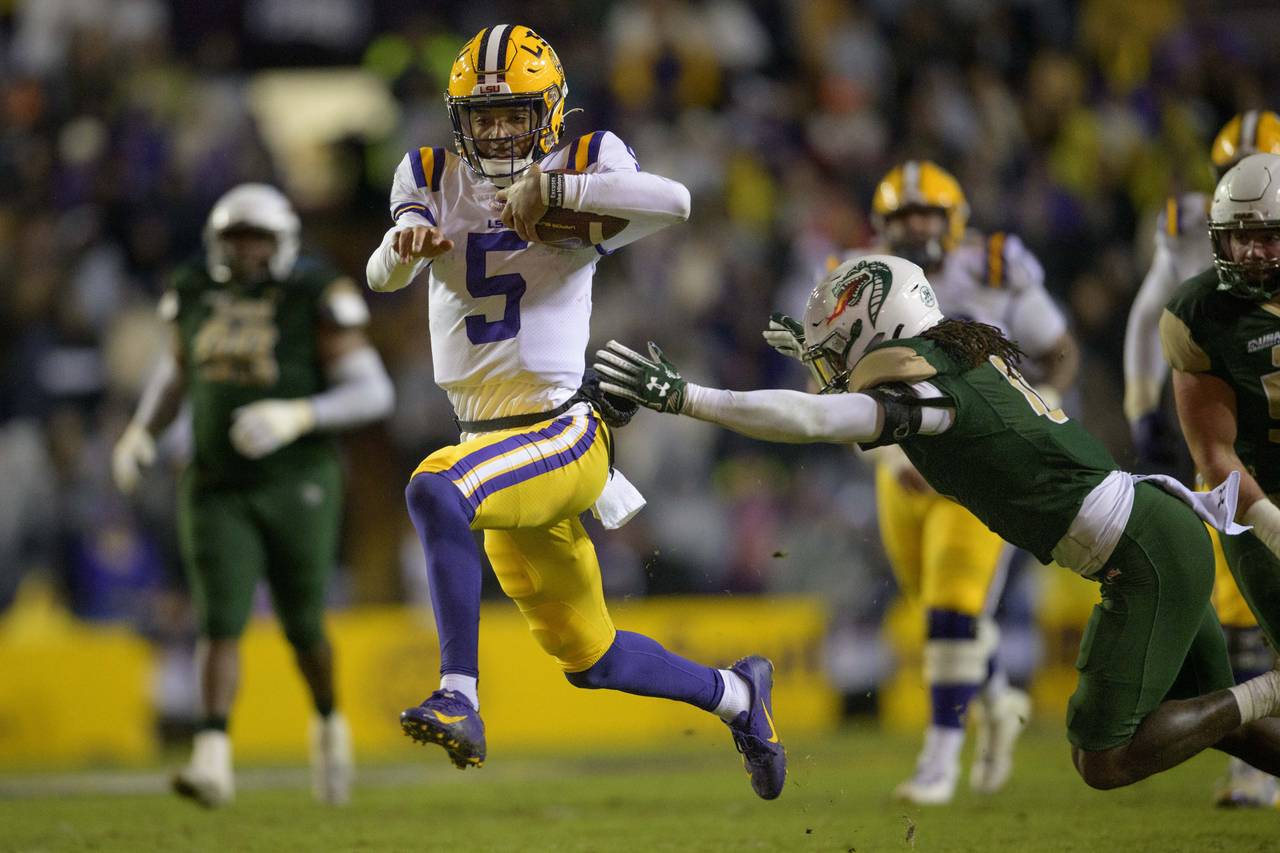 LSU quarterback Jayden Daniels (5) runs past UAB safety Keondre Swoopes (0) during the first half a...