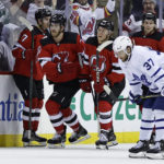 
              New Jersey Devils defenseman Dougie Hamilton (7) and teammates celebrate his goal, as Toronto Maple Leafs defenseman Timothy Liljegren (37) skates past during the third period of an NHL hockey game Wednesday, Nov. 23, 2022, in Newark, N.J. The Maple Leafs won 2-1. (AP Photo/Adam Hunger)
            