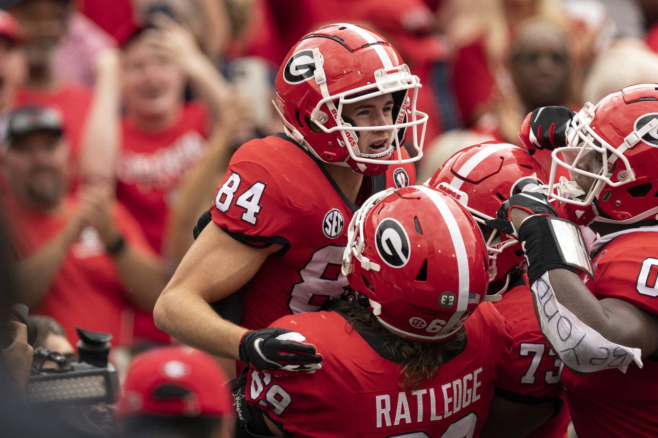 Georgia wide receiver Ladd McConkey (84) celebrates a touchdown catch with teammates during the fir...