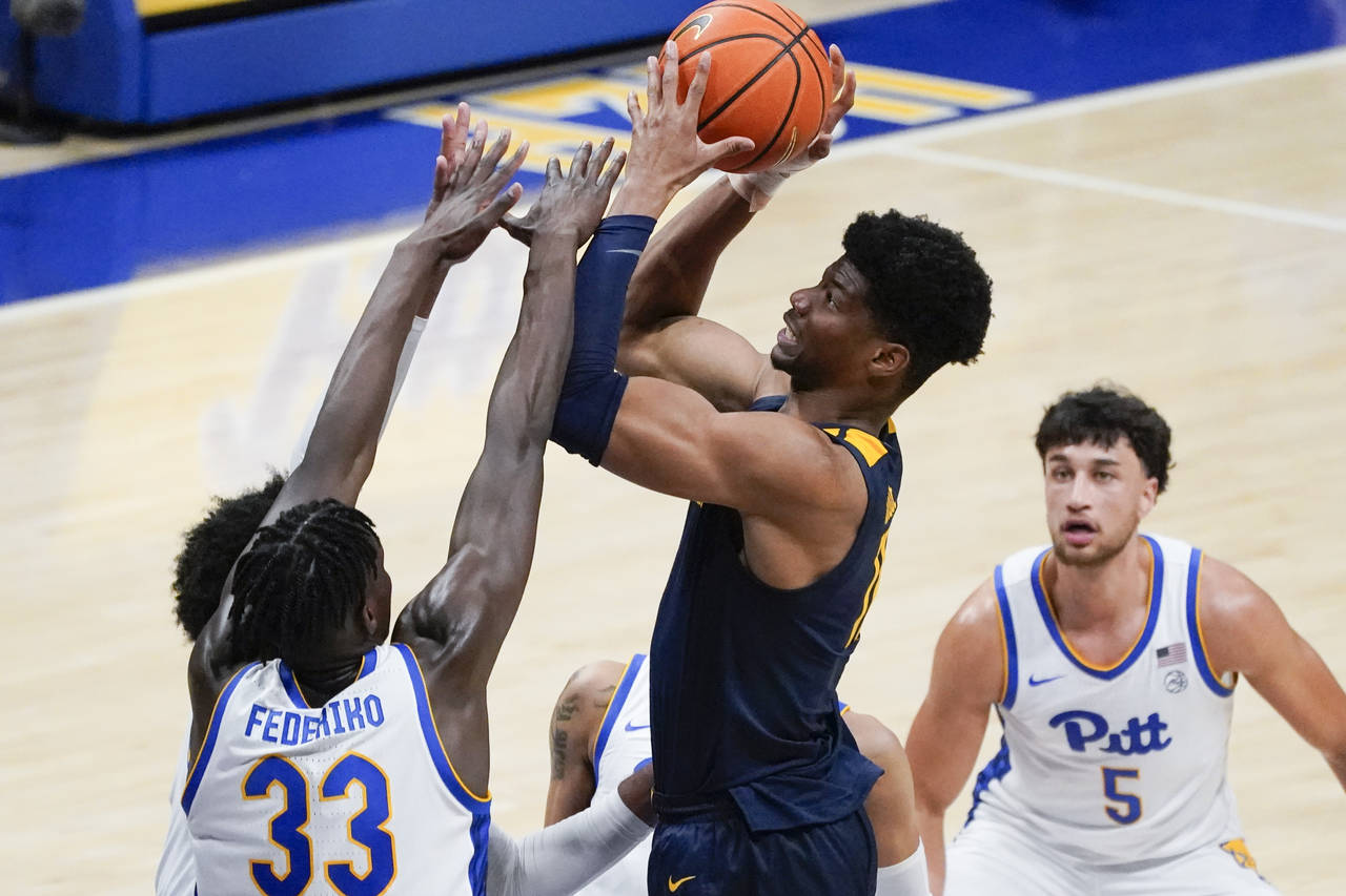West Virginia's Mohamed Wague, second from right,shoots over Pittsburgh's Federiko Federiko (33) du...