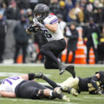 
              Northwestern running back Evan Hull (26) leaps for a gain as he runs against Purdue during the second half of an NCAA college football game in West Lafayette, Ind., Saturday, Nov. 19, 2022. Purdue defeated Northwestern 17-9. (AP Photo/Michael Conroy)
            