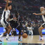 
              Los Angeles Clippers guard Reggie Jackson (1) dribble the ball between San Antonio Spurs guard Tre Jones (33) and forward Jeremy Sochan (10) during the first half of an NBA basketball game Saturday, Nov. 19, 2022, in Los Angeles. (AP Photo/Allison Dinner)
            