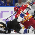 
              Calgary Flames center Mikael Backlund (11) knocks down Tampa Bay Lightning defenseman Nick Perbix (48) during the second period of an NHL hockey game Thursday, Nov. 17, 2022, in Tampa, Fla. (AP Photo/Chris O'Meara)
            
