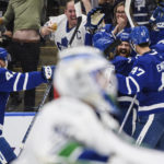 
              Toronto Maple Leafs defenseman Jordie Benn (18) celebrates with teammates after scoring against the Vancouver Canucks during the second period of an NHL hockey game in Toronto, Saturday, Nov. 12, 2022. (Christopher Katsarov/The Canadian Press via AP)
            
