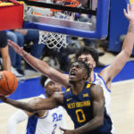
              West Virginia's Kedrian Johnson (0) shoots as Pittsburgh's Nate Santos defends during the second half of an NCAA college basketball game, Friday, Nov. 11, 2022, in Pittsburgh. West Virginia won 81-56. (AP Photo/Keith Srakocic)
            
