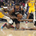 
              Los Angeles Clippers guard Paul George, center, goes after s loose ball along with Los Angeles Lakers guard Patrick Beverley, left, and forward Anthony Davis during the first half of an NBA basketball game Wednesday, Nov. 9, 2022, in Los Angeles. (AP Photo/Mark J. Terrill)
            