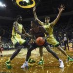 
              Oregon centers N'Faly Dante (1) and Nate Bittle (32) pressure Houston guard Tramon Mark, center, during the first half of an NCAA college basketball game Sunday, Nov. 20, 2022, in Eugene, Ore. (AP Photo/Andy Nelson)
            