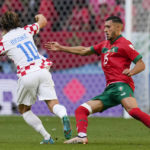 
              Croatia's Luka Modric (10) runs with the ball against Morocco's Selim Amallah (15) during the World Cup group F soccer match between Morocco and Croatia, at the Al Bayt Stadium in Al Khor , Qatar, Wednesday, Nov. 23, 2022. (AP Photo/Themba Hadebe)
            