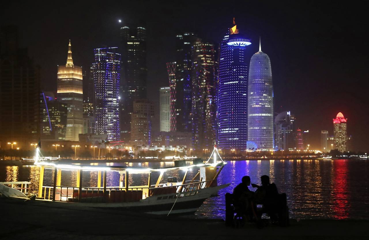 FILE - Two people talk at the Corniche waterfront promenade in Doha, Qatar on May 14, 2019. Qatar i...