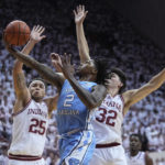 
              CORRECTS CITY TO BLOOMINGTON, INSTEAD OF INDIANAPOLIS - North Carolina guard Caleb Love (2) drives to the basket against Indiana forward Race Thompson (25) and guard Trey Galloway (32) during the first half of an NCAA college basketball game in Bloomington, Ind., , Wednesday, Nov. 30, 2022. (AP Photo/Darron Cummings)
            