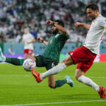 
              Saudi Arabia's Mohammed Al-Burayk tries to block a shot from Poland's Bartosz Bereszynski soccer match between Poland and Saudi Arabia, at the Education City Stadium in Al Rayyan , Qatar, Saturday, Nov. 26, 2022. (AP Photo/Manu Fernandez)
            