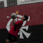 
              A boy chests a soccer ball at the Flamengo Sao Goncalo school where Brazilian player Vinicius Jr., who was selected to compete in the 2022 Qatar World Cup, trained early in his career, in Sao Goncalo, Rio de Janeiro state, Brazil, Monday, Nov. 7, 2022. Four years ago teenager Vinicius Jr. took his first medal from a professional soccer tournament home, a place where drug gangs and vigilantes fight for control and children dribble past garbage on the streets. (AP Photo/Bruna Prado)
            