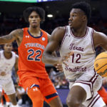 
              Texas Southern guard Zytarious Mortle (12) drives as Auburn guard Allen Flanigan (22) defends during the first half of an NCAA college basketball game Friday, Nov. 18, 2022, in Auburn, Ala. (AP Photo/Butch Dill)
            