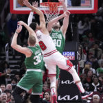 
              Boston Celtics' Luke Kornet (40) fouls Chicago Bulls' Zach LaVine as Sam Hauser also defends during the first half of an NBA basketball game Monday, Nov. 21, 2022, in Chicago. (AP Photo/Charles Rex Arbogast)
            