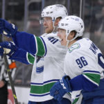 
              Vancouver Canucks center Elias Pettersson (40) points to teammates as he celebrates with Andrei Kuzmenko (96) after scoring a goal against the San Jose Sharks during the third period of an NHL hockey game Sunday, Nov. 27, 2022, in San Jose, Calif. The Canucks won 4-3 in overtime. (AP Photo/Tony Avelar)
            