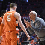 
              Syracuse coach Jim Boeheim, right, talks with Justin Taylor (5) and a teammate during the first half of an NCAA college basketball game against Illinois, Tuesday, Nov. 29, 2022, in Champaign, Ill. (AP Photo/Michael Allio)
            