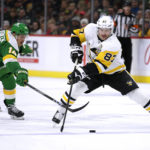 
              Pittsburgh Penguins center Sidney Crosby (87) controls the puck in front of Minnesota Wild center Joel Eriksson Ek (14) during the second period of an NHL hockey game Thursday, Nov. 17, 2022, in St. Paul, Minn. (AP Photo/Andy Clayton-King)
            
