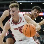 
              Wisconsin's Tyler Wahl drives past Stanford's Brandon Angel during the first half of an NCAA college basketball game Friday, Nov. 11, 2022, in Milwaukee. The game is being played at American Family Field, home of the Milwaukee Brewers. (AP Photo/Morry Gash)
            