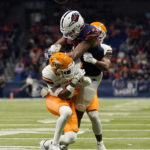 
              UTEP safety Tyson Wilson, front, and UTEP defensive back Josiah Allen, rear, break up a pass intended for UTSA wide receiver De'Corian Clark, center, during the first half of an NCAA college football game in San Antonio, Saturday, Nov. 26, 2022. (AP Photo/Eric Gay)
            