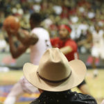 
              A spectator wearing a cowboy hat watches Texas Tech take on Louisville during the first half of an NCAA college basketball game, Tuesday, Nov. 22, 2022, in Lahaina, Hawaii. (AP Photo/Marco Garcia)
            