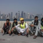 
              Pakistani migrant laborers pose for a photograph, as they take a break, on the corniche, overlooking the skyline of Doha, Qatar, Wednesday, Oct. 19, 2022. One of the world’s biggest sporting events has thrown an uncomfortable spotlight on Qatar’s labor system, which links workers’ visas to employers and keeps wages low for workers toiling in difficult conditions. (AP Photo/Nariman El-Mofty)
            