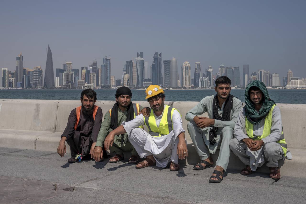 Pakistani migrant laborers pose for a photograph, as they take a break, on the corniche, overlookin...