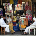 
              Shop staff wait for customers in front of a souvenir shop at the Souq Waqif Market in Doha, Qatar, Friday, Nov. 25, 2022. (AP Photo/Eugene Hoshiko)
            