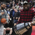 
              Toronto Argonauts' Henoc Muamba holds the CFL Grey Cup as Drake, left, looks on during a break in the first half of an NBA basketball game between the Brooklyn Nets and the Toronto Raptors on Wednesday, Nov. 23, 2022, in Toronto. (Chris Young/The Canadian Press via AP)
            