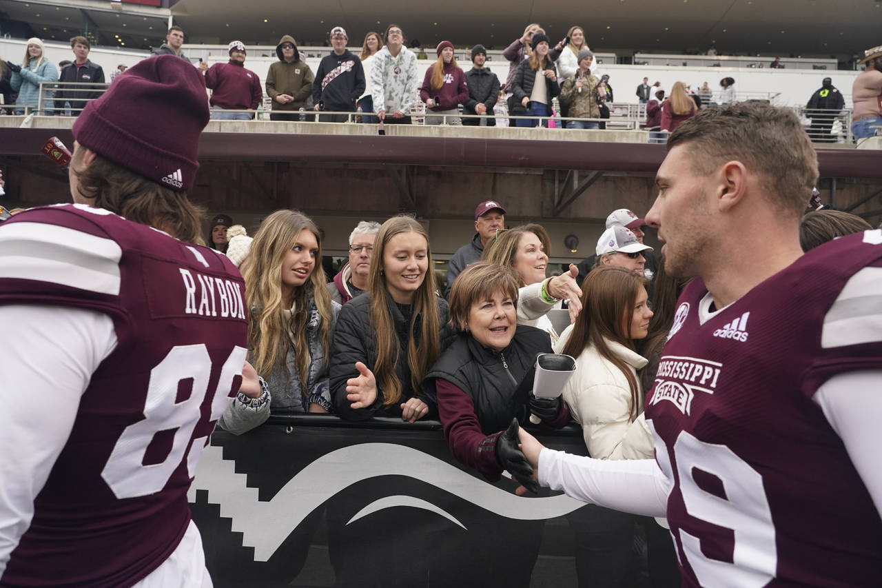 Mississippi State placekicker Massimo Biscardi, right, reaches out to receive congratulatory handsh...