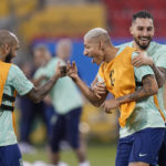 
              Brazil's Richarlison, center, jokes with teammates Alex Telles, right, and Dani Alves during a training session at the Grand Hamad stadium in Doha, Qatar, Sunday, Nov. 27, 2022. Brazil will face Switzerland in a group G World Cup soccer match on Nov. 28. (AP Photo/Andre Penner)
            