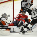 
              Washington Capitals defenseman Martin Fehervary (42) battles for the puck against Philadelphia Flyers goaltender Felix Sandstrom (32) and center Kevin Hayes (13) during the third period of an NHL hockey game, Wednesday, Nov. 23, 2022, in Washington. The Capitals won 3-2 in overtime. (AP Photo/Nick Wass)
            