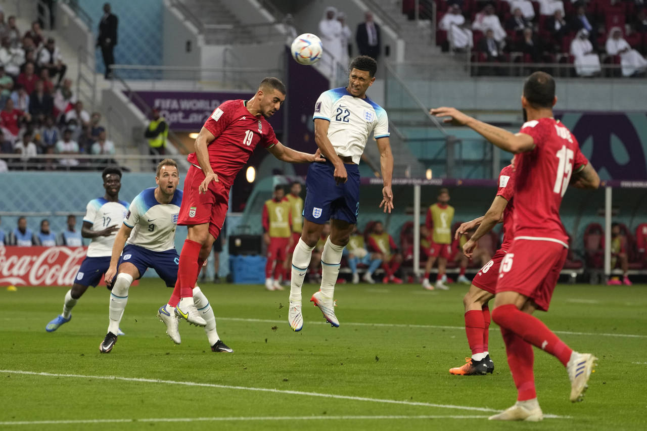 England's Jude Bellingham, centre, scores his side's opening goal during the World Cup group B socc...